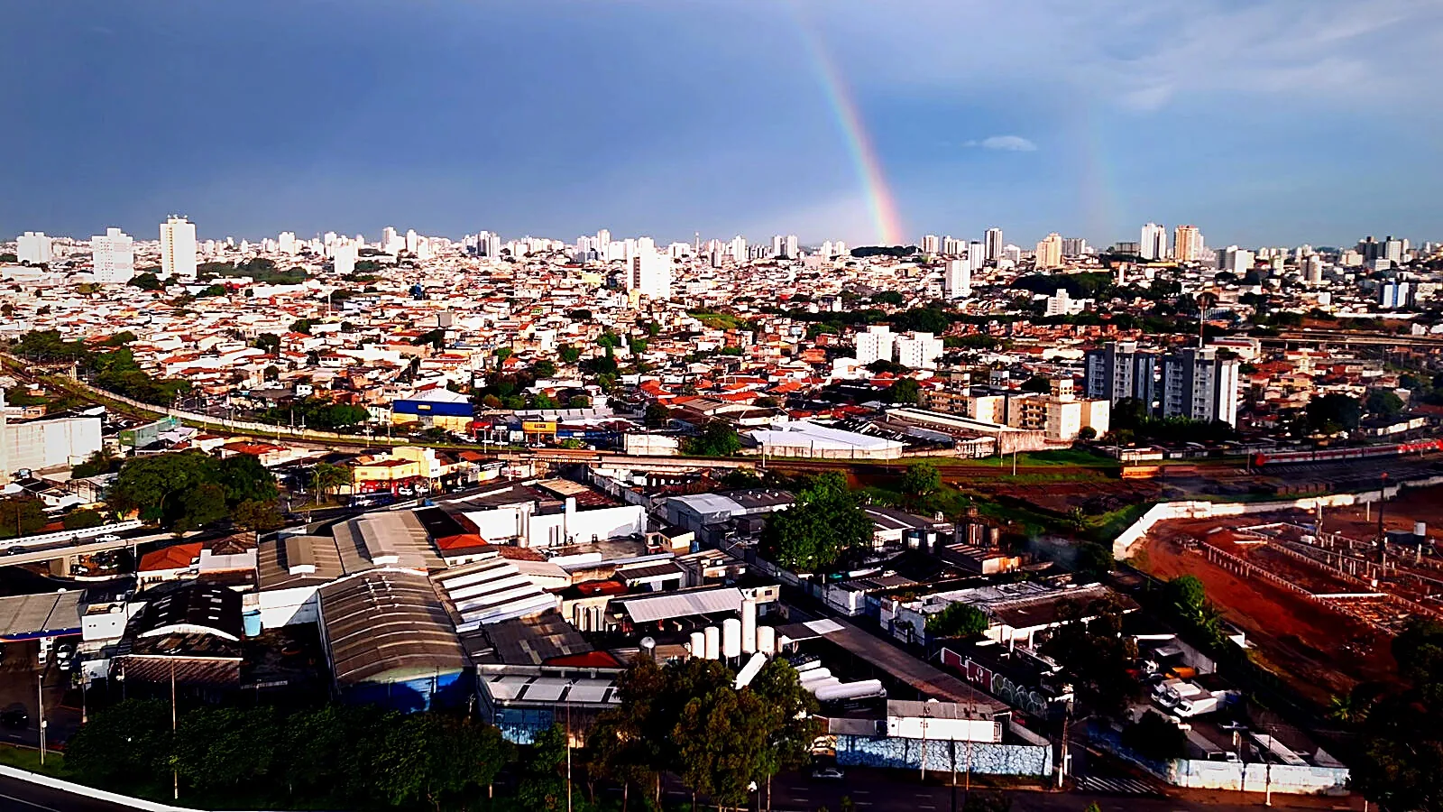Vista aérea de planta industrial de gases com arco-íris ao fundo