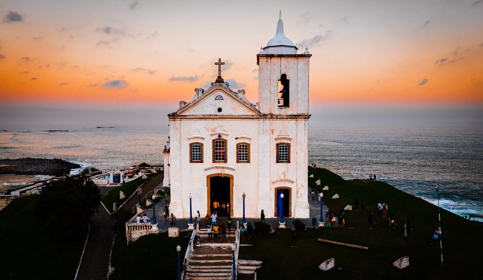 Igreja histórica sobre o morro à beira-mar no pôr do sol, imagem de drone